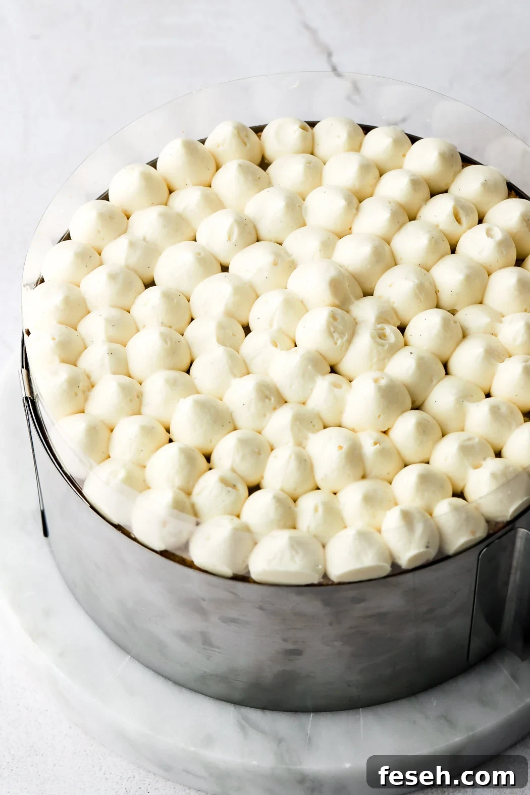 pipe poofs of crème mousseline on top of the cake