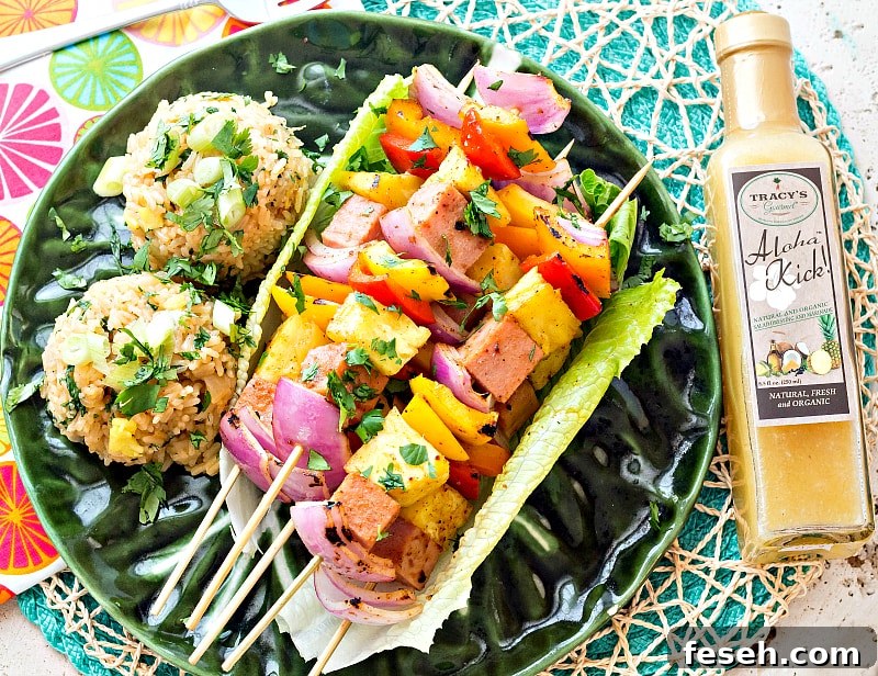 A plate of Hawaiian Pineapple Ham Skewers with Sweet and Hot Pineapple Rice next to a bottle of Tracy's Gourmet Aloha Kick Dressing.