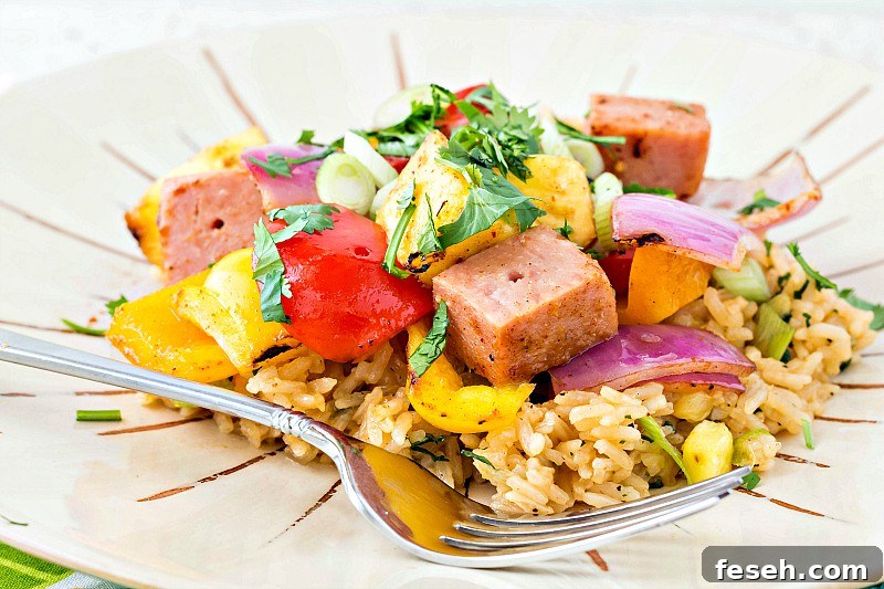 A white plate with rice and all ingredients on a skewer removed and place on top of rice with a fork.