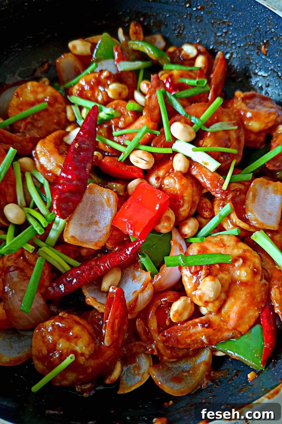Image showing vibrant looking shrimp kung pao topped with peanuts and scallion greens.