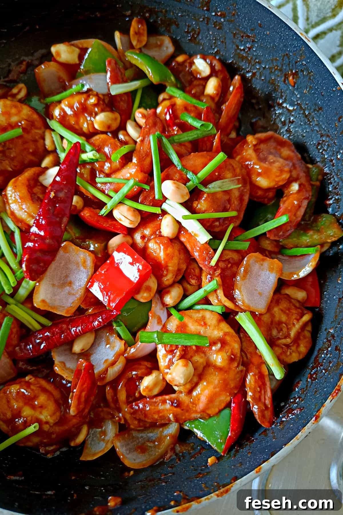 Image showing tender, juicy shrimps coated with kung pao sauce, topped with peanuts and scallions.