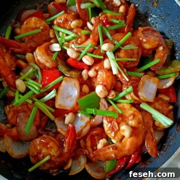 Image showing vibrant looking kung pao shrimp in a black pan.
