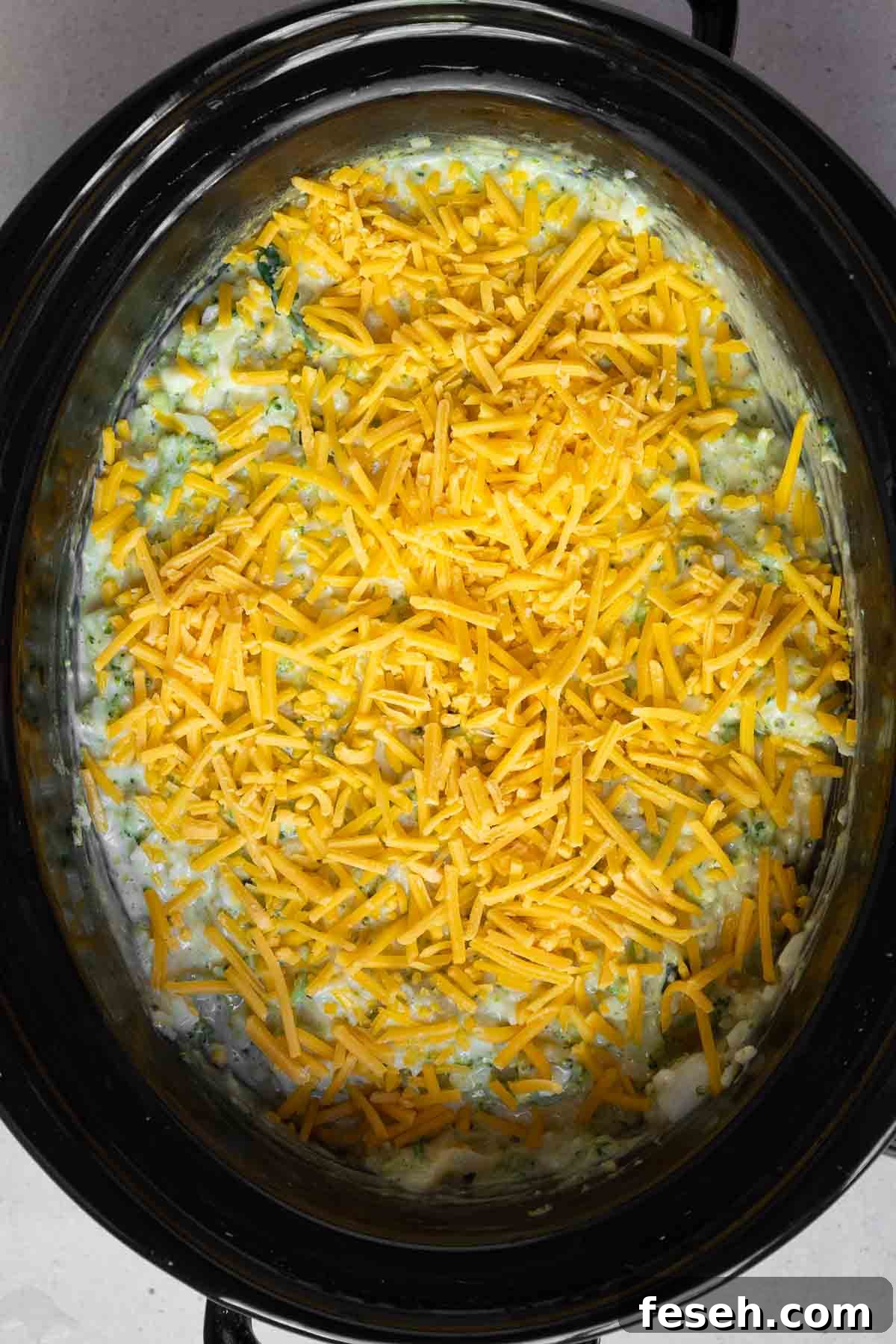 Shredded cheddar sprinkled in an even layer over the broccoli filling.