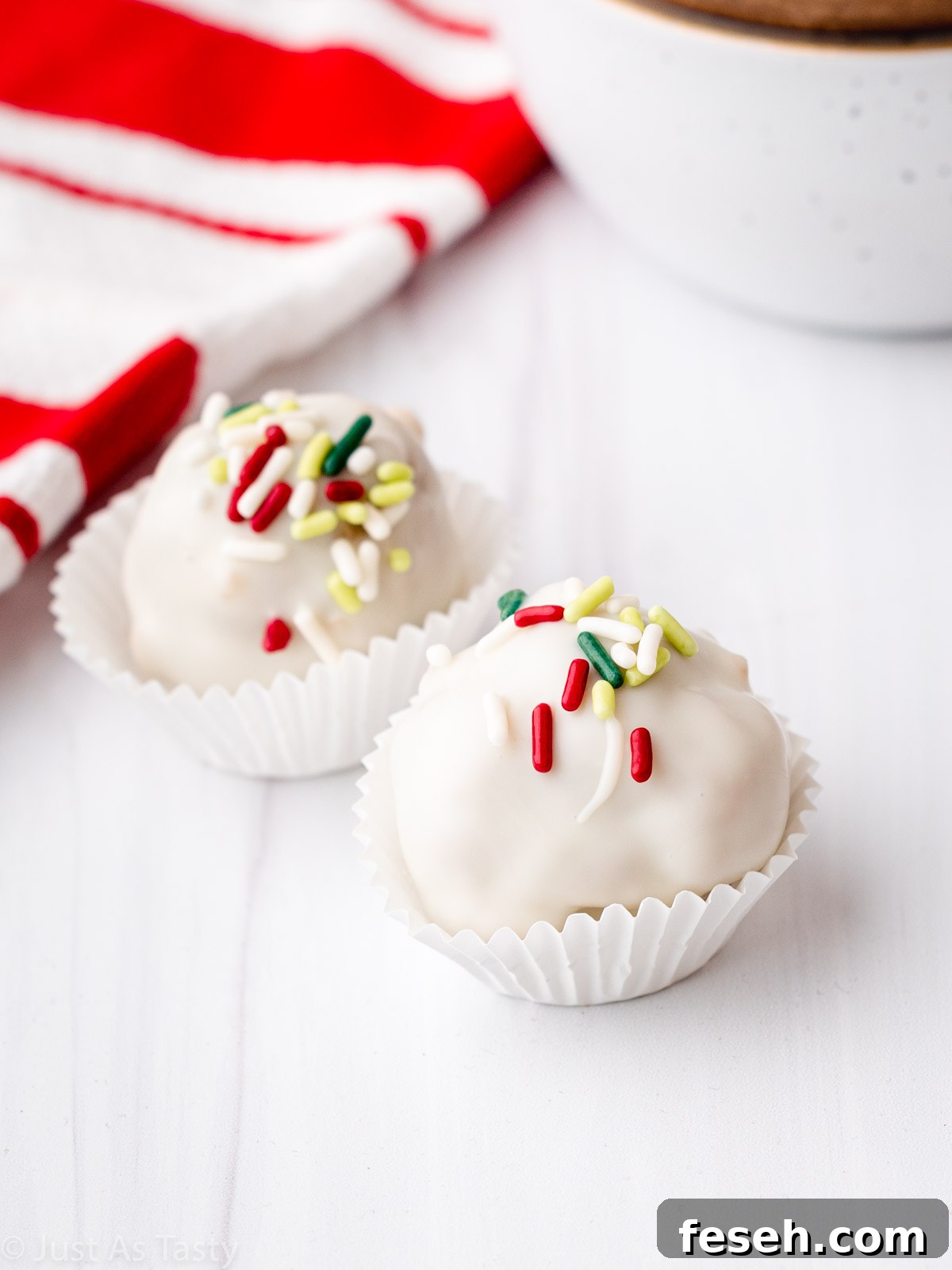 Two white chocolate gingerbread truffles in mini paper candy liners.