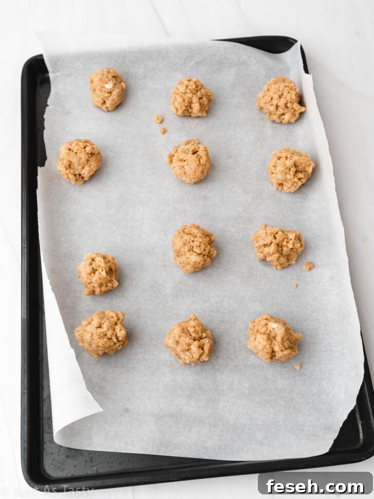 Uncoated gingerbread truffles scooped into balls on a lined baking sheet.
