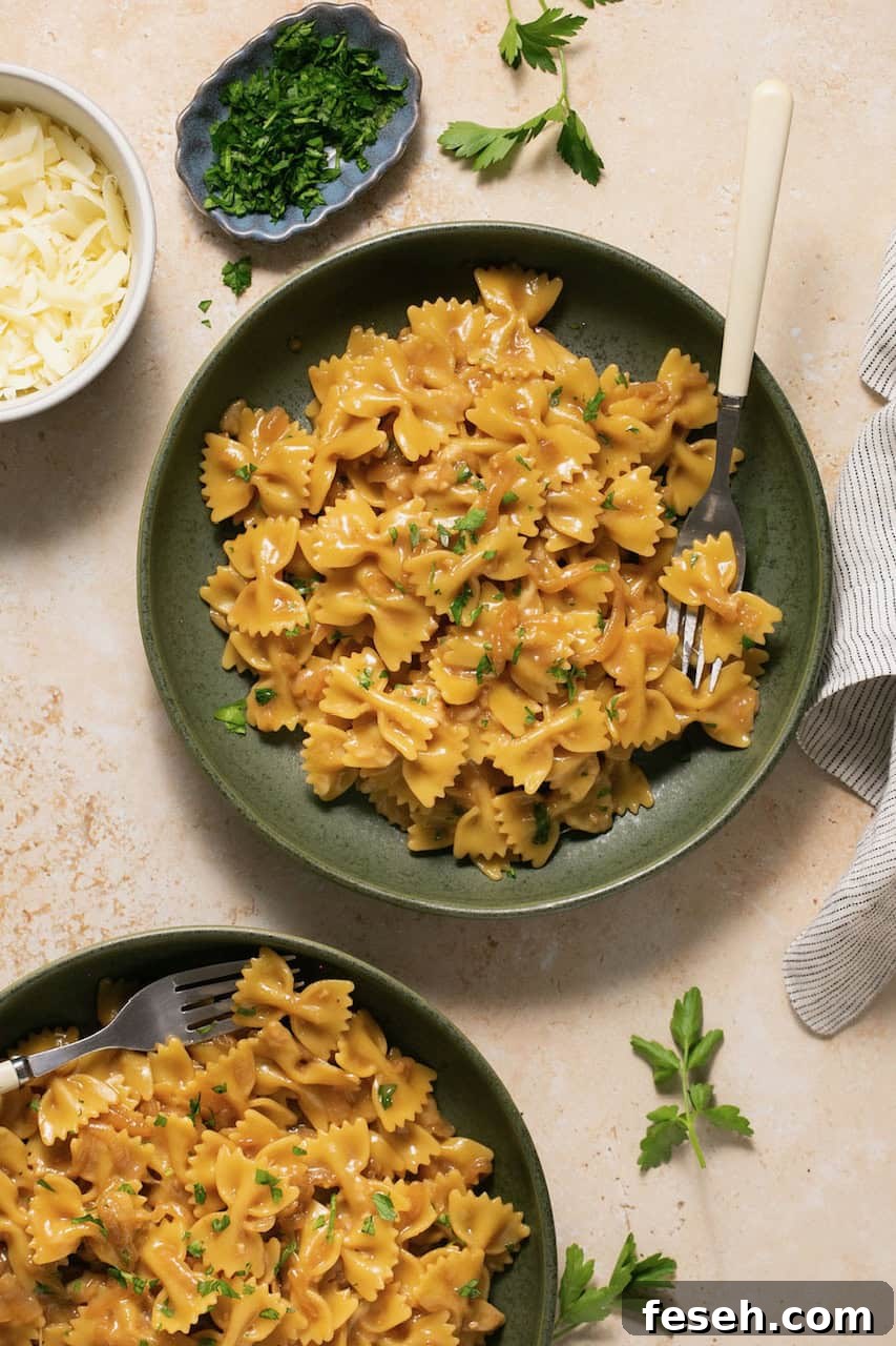 an overhead shot of a green bowl filled with gluten-free pasta with a fork resting on the side. 