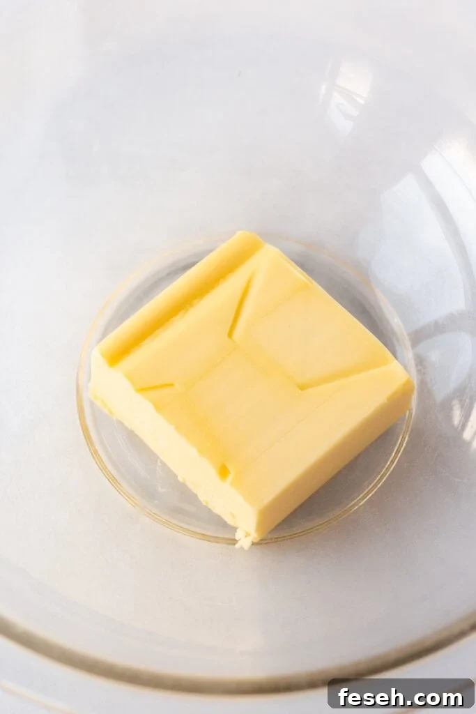 A half a cup of butter in a clear microwavable bowl.