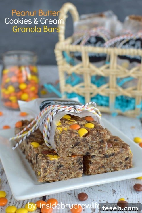 A white plate with peanut butter cookies and cream granola bars on it and jar of Reese's candies behind it