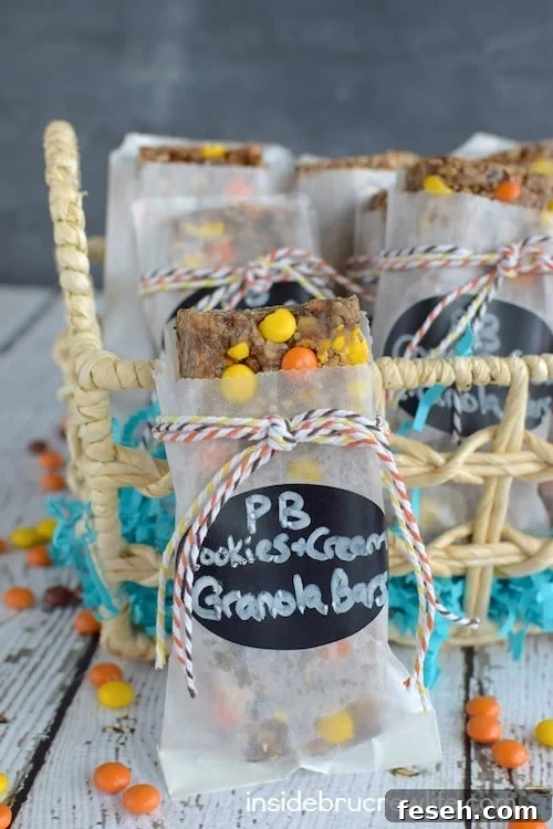 A peanut butter cookies and cream granola bar packaged in a white bag with a label and twine standing by a basket
