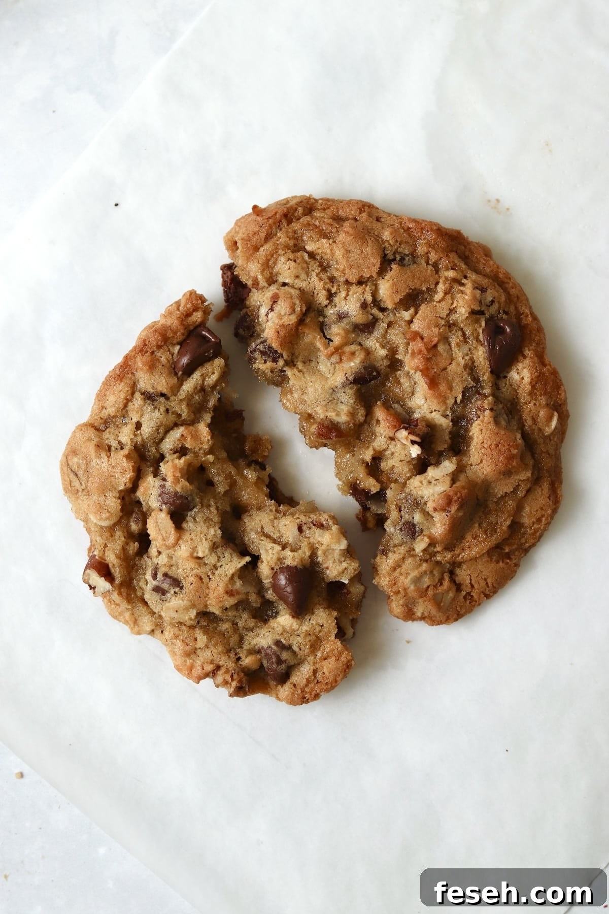Single serve cowboy cookie with oats and pecans broken in half.