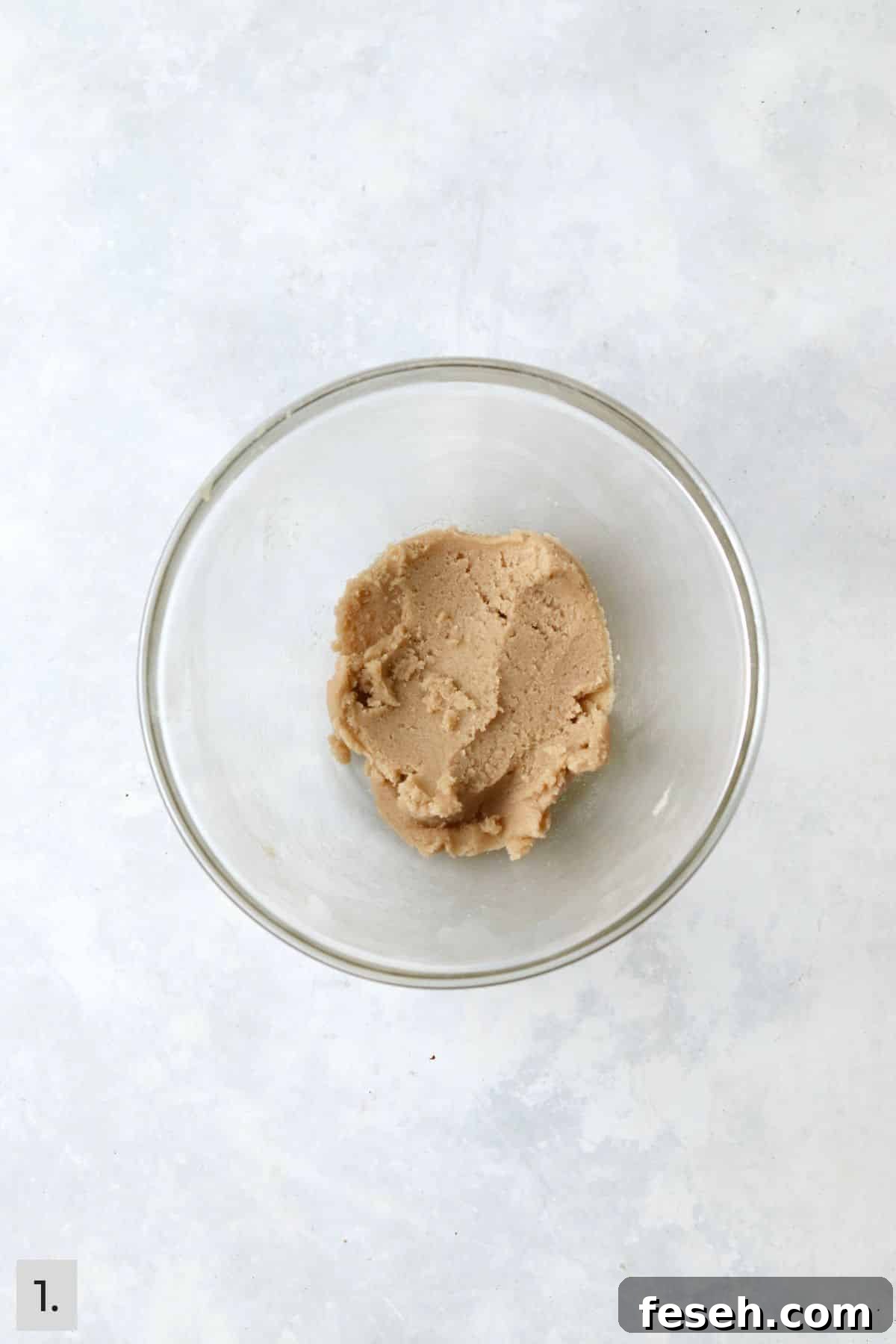 Butter and sugars creamed in a glass bowl.