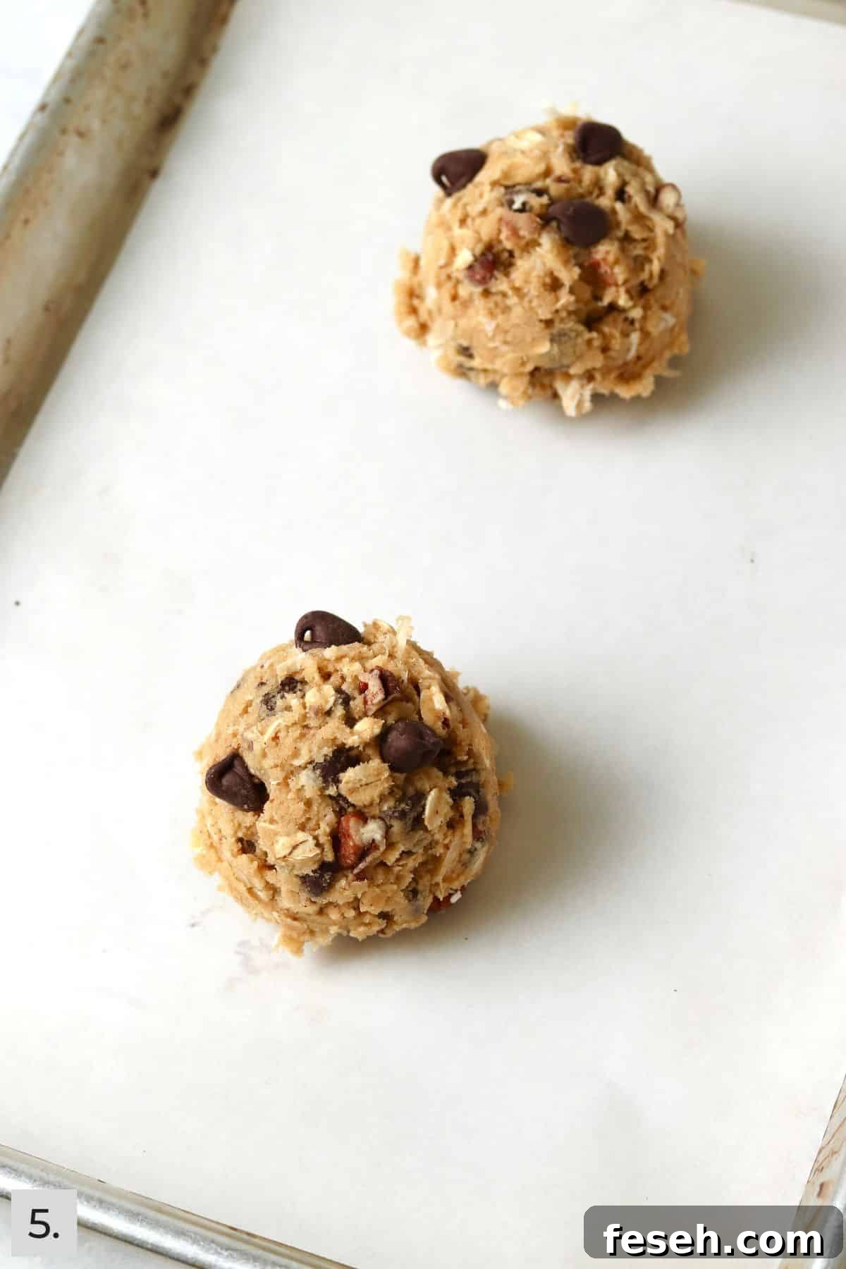Cowboy cookie dough ball on a baking sheet.