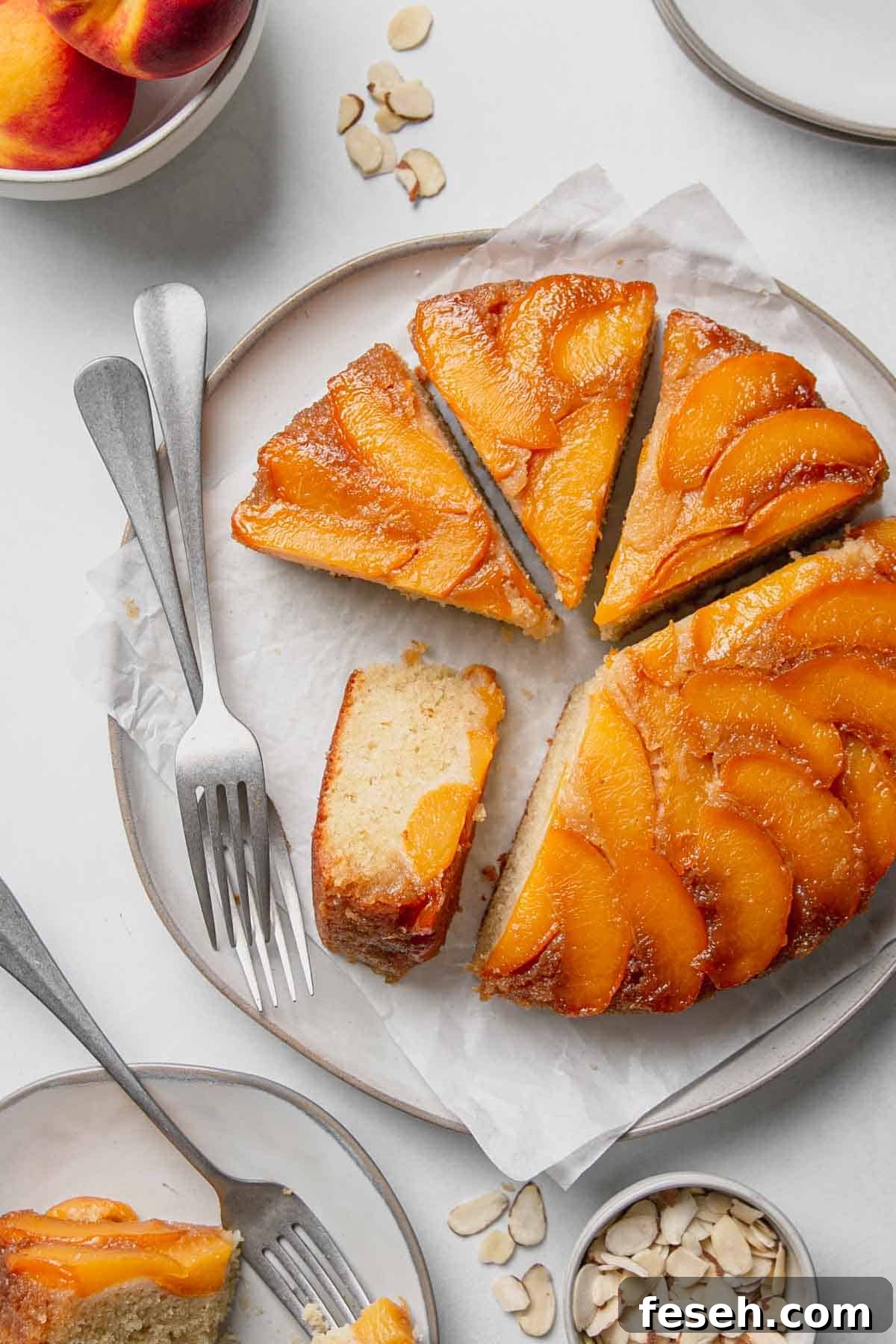 Sliced gluten free upside down cake on a large plate with forks. One slice on its side.
