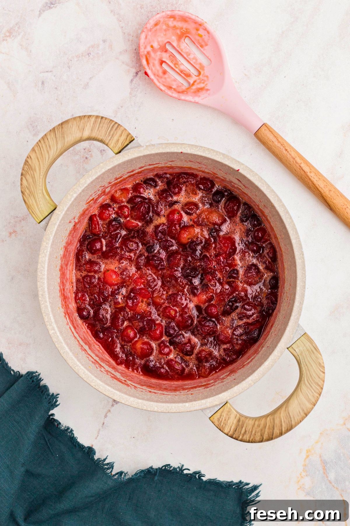 Cranberries, sugar, and juice, simmered together making a cranberry orange sauce. 