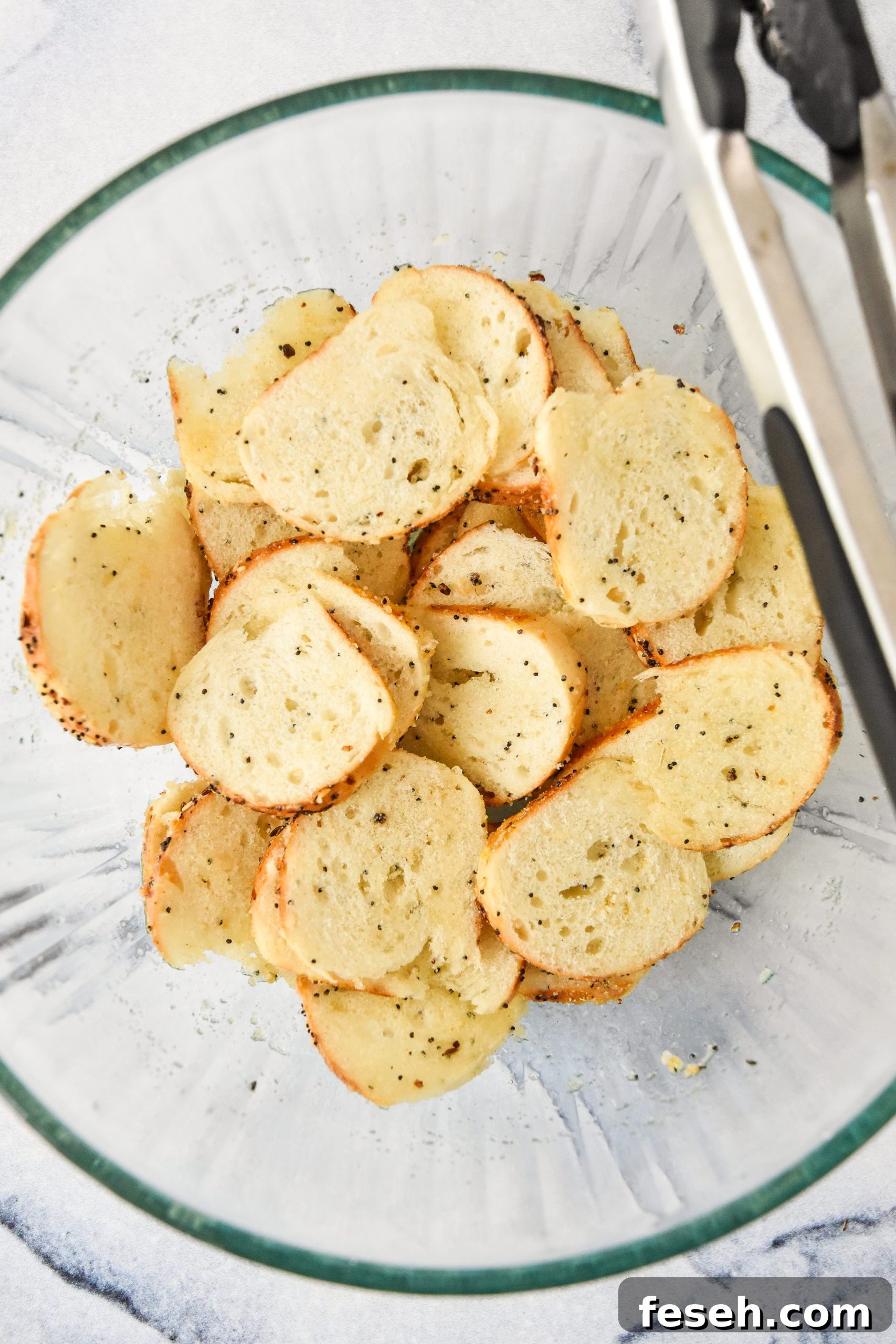 mixing bagel chip ingredients in a large glass bowl.