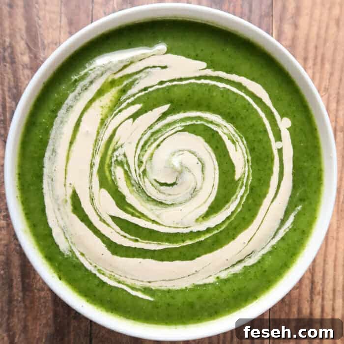 creamy celery soup with spinach, with a swirl of vegan cream sauce on top