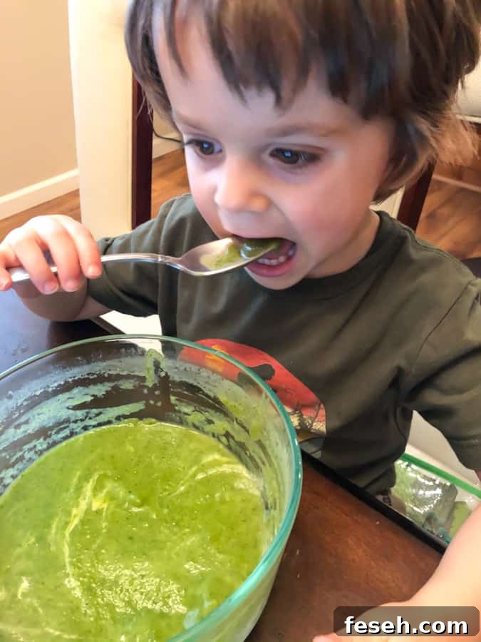my 3 year old eating a bowl of the vegan creamy celery soup with spinach, kid-approved!