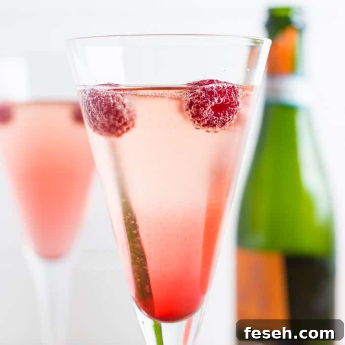 Raspberries floating on the surface of a glass of Kir Royale