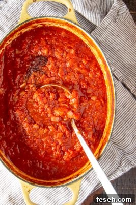 This spicy tomato sauce develops layers of flavor from roasting in the oven. It only takes 15 minutes to put together before sliding it into the oven, and can be used for many recipes.