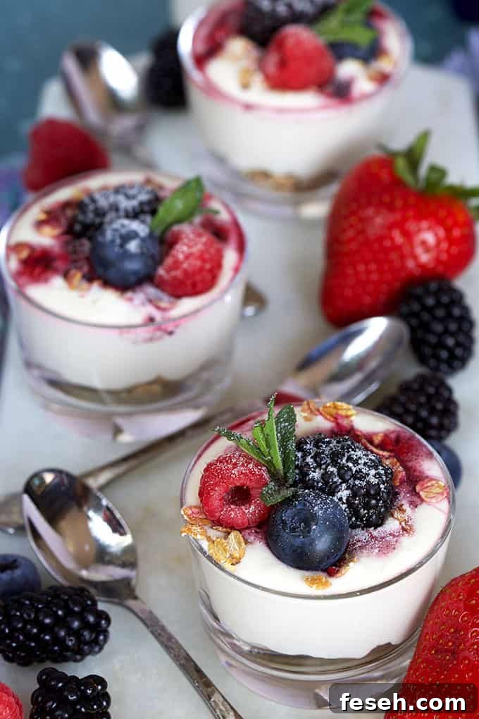 Three mini cheesecake parfaits in a glass jar on a white background from TheSuburbanSoapbox.com