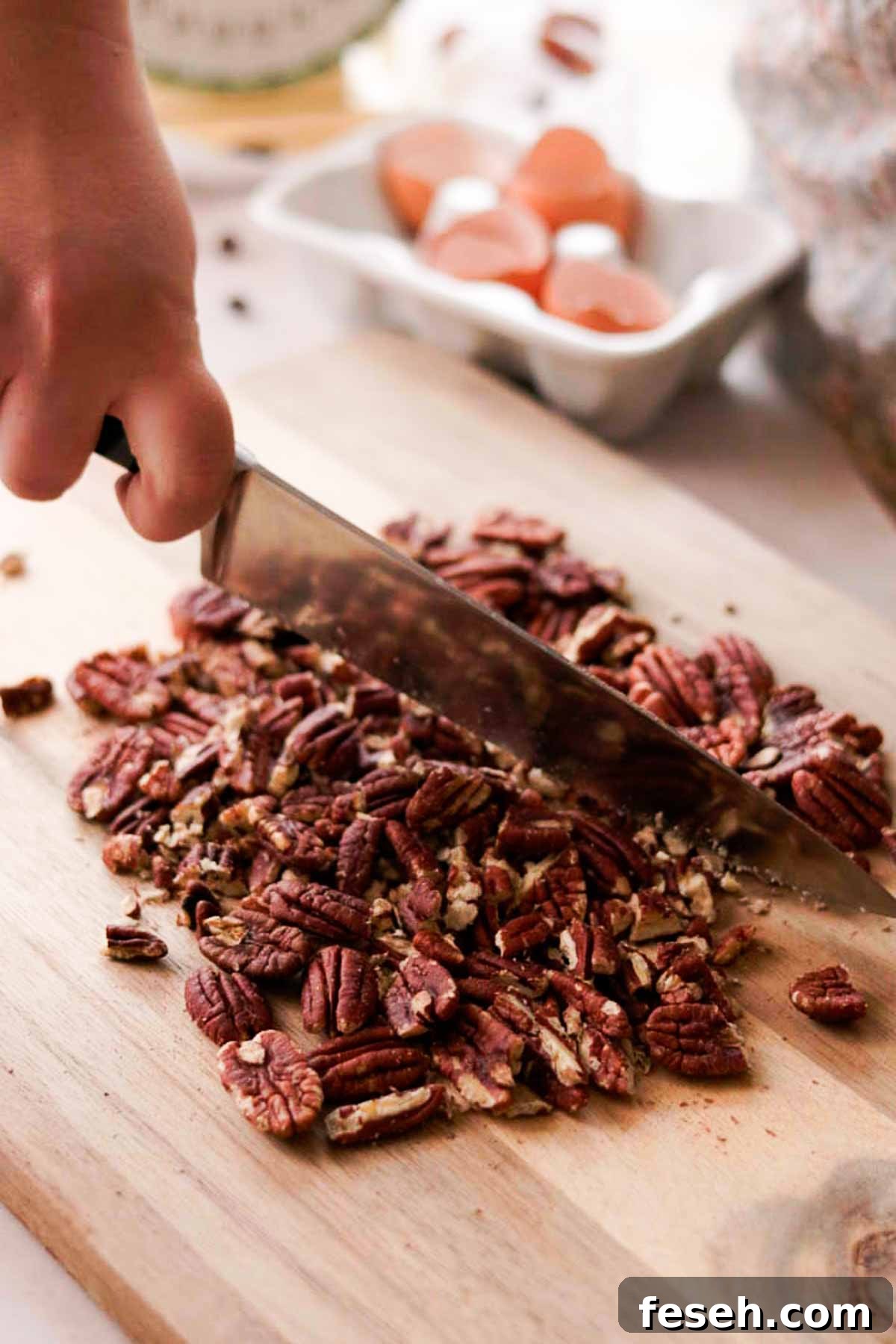 chopping pecans with a knife on cutting board