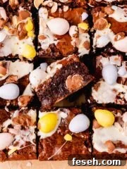 brownies topped and filled with mini eggs on parchment paper