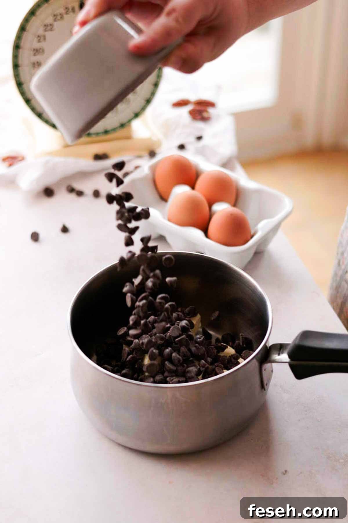 adding chocolate chips to a saucepan with butter
