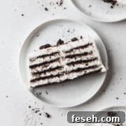 A slice of icebox cake on a white plate with Oreo crumbs.