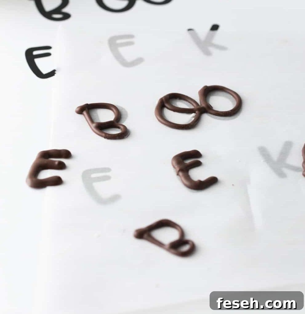 Sheet of chocolate letters to make edible Halloween cupcake toppers. Boo and EEK phrases.
