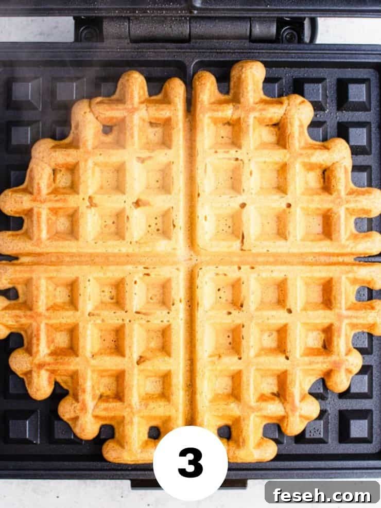 Overhead view of cooked waffle on a waffle iron.