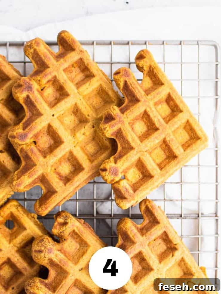 Overhead view of pumpkin waffles on a cooling rack.