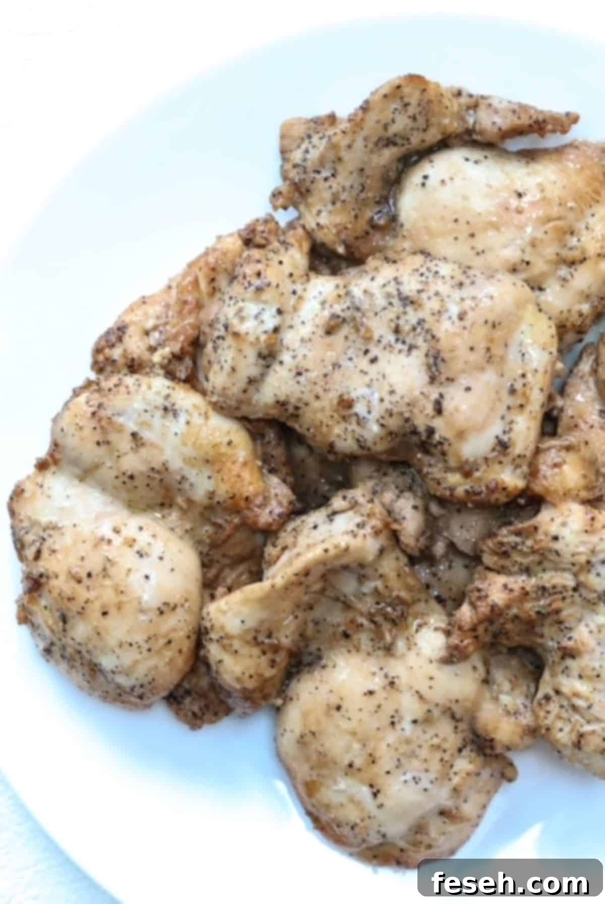 Cooked Lemon Pepper Chicken on a white plate.