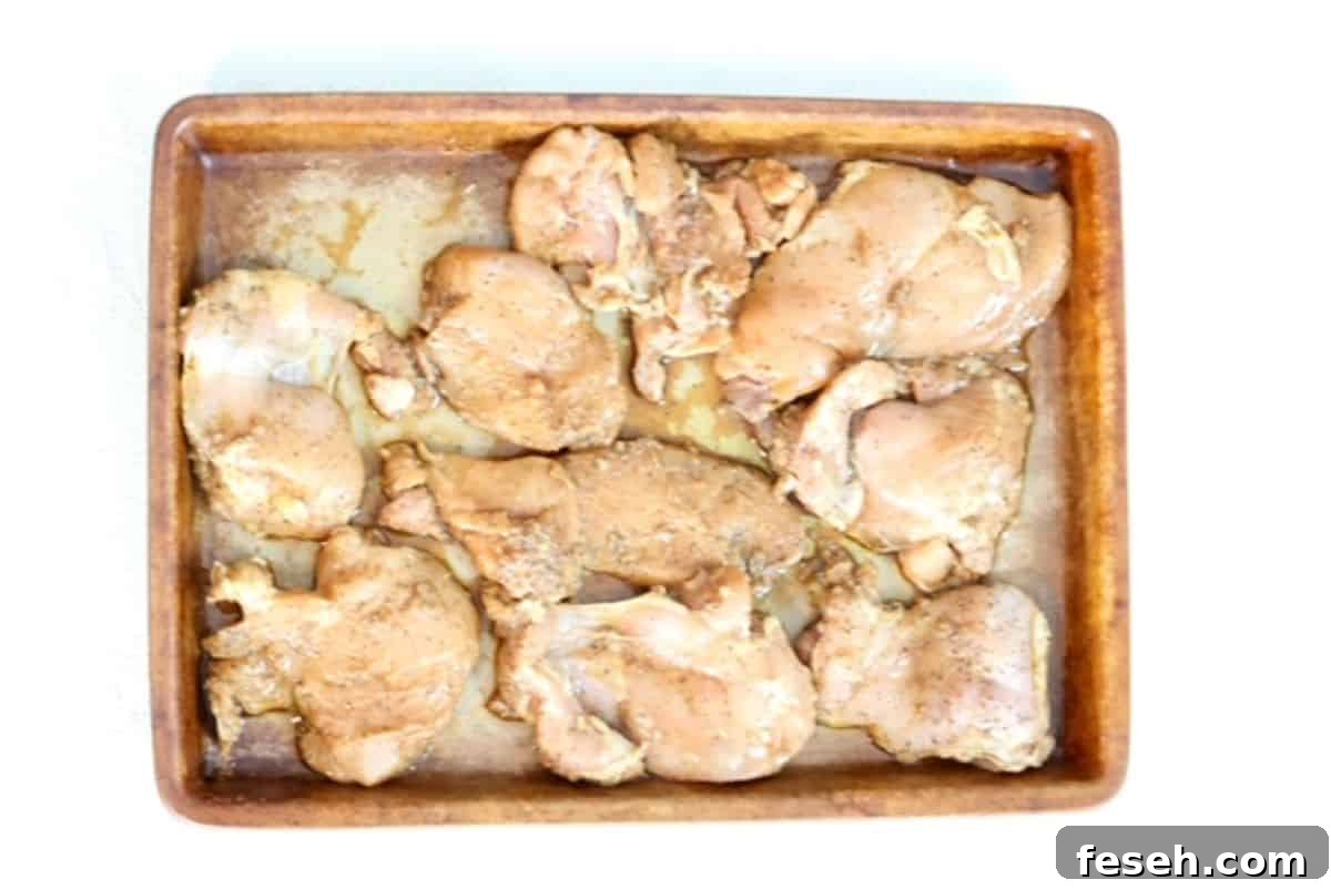 Marinated chicken pieces on a stoneware bar pan.