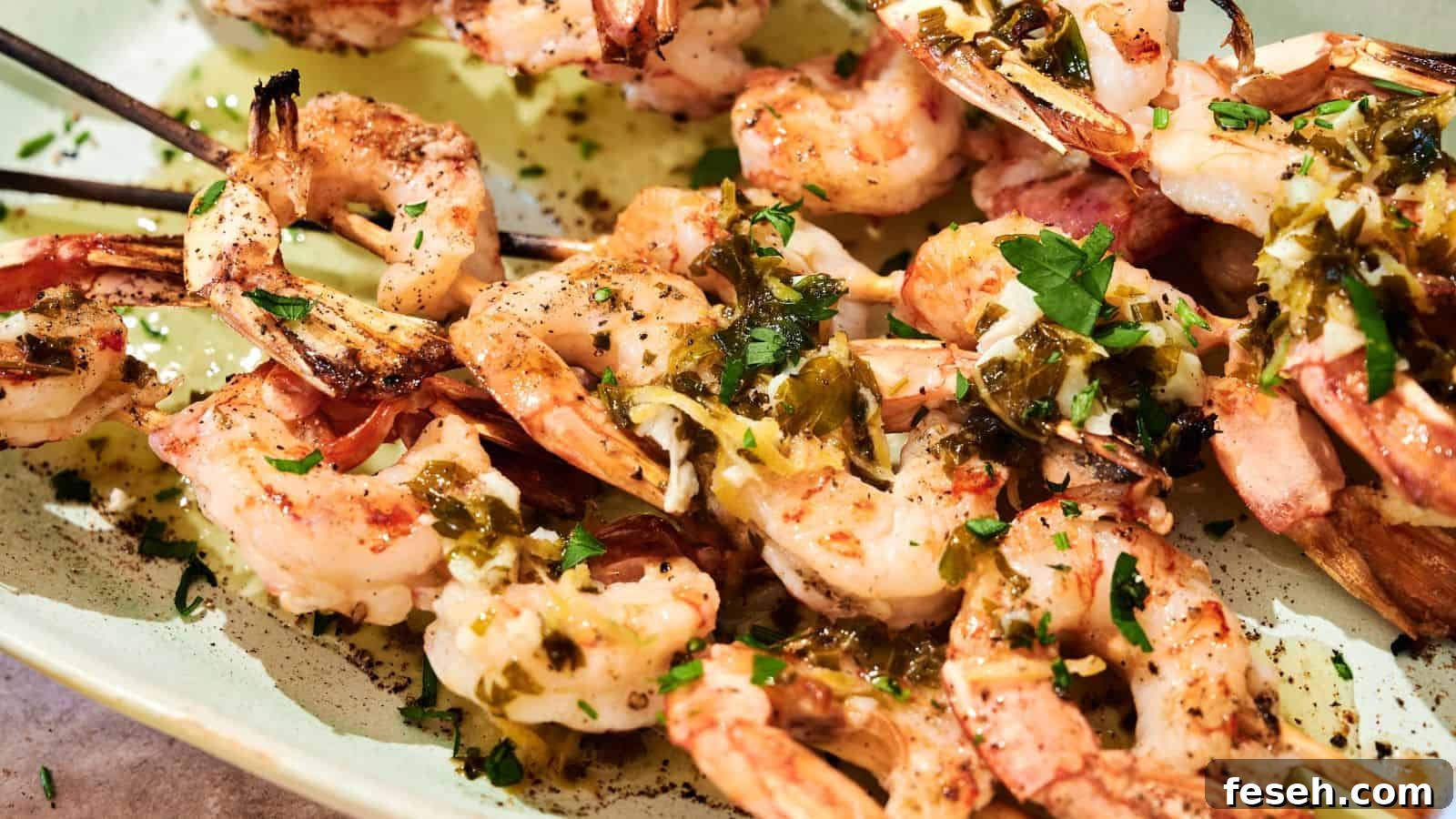 Grilled shrimp skewers served on a plate, topped with chopped herbs and a drizzle of sauce.