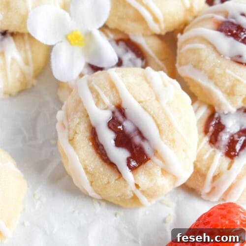 strawberry cookie leaning agains pile of shortbread cookies.