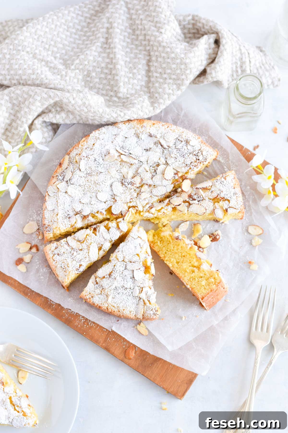 almond cake on wooden board, sliced into triangles. 