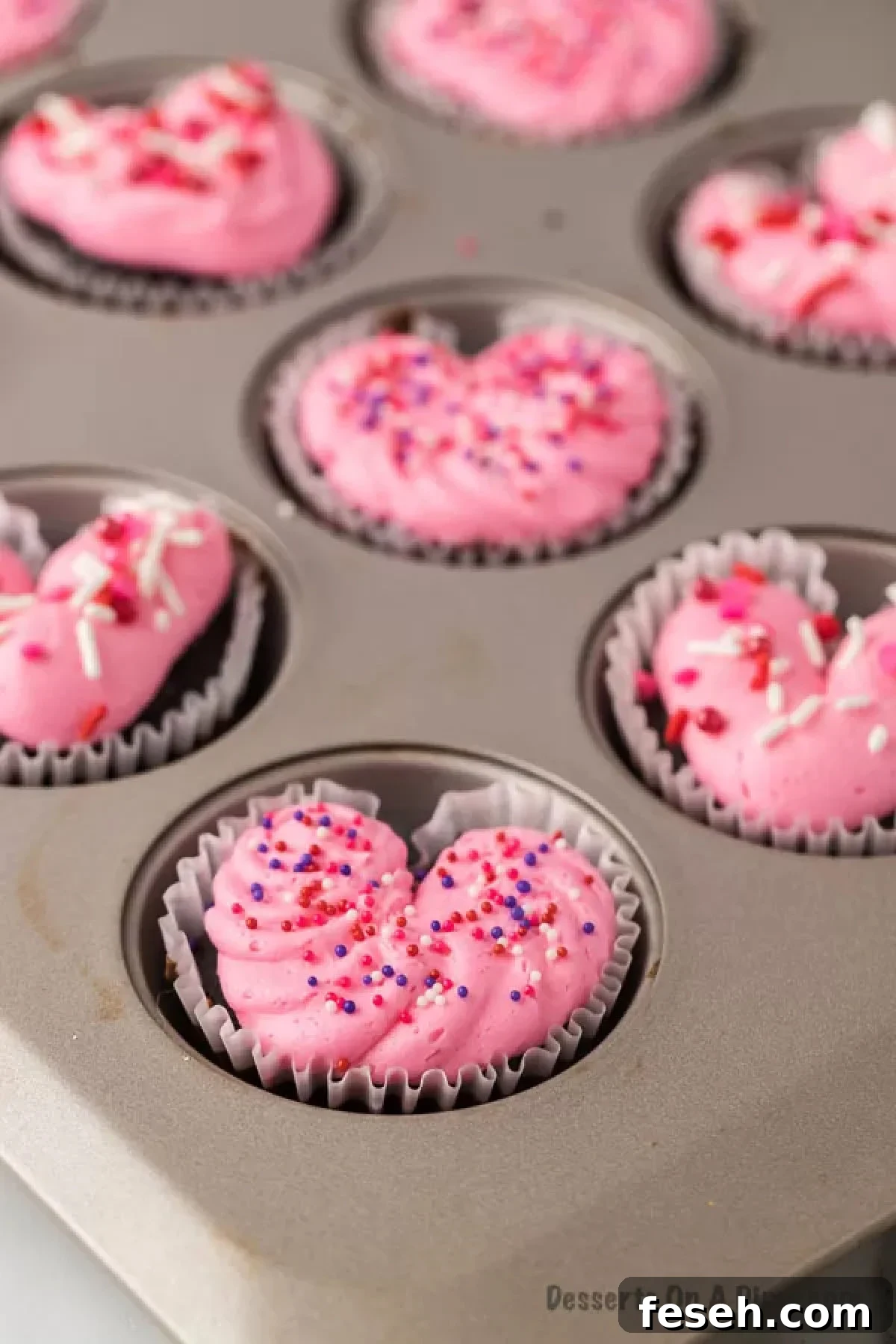 Heart cupcakes decorated with icing and sprinkles.