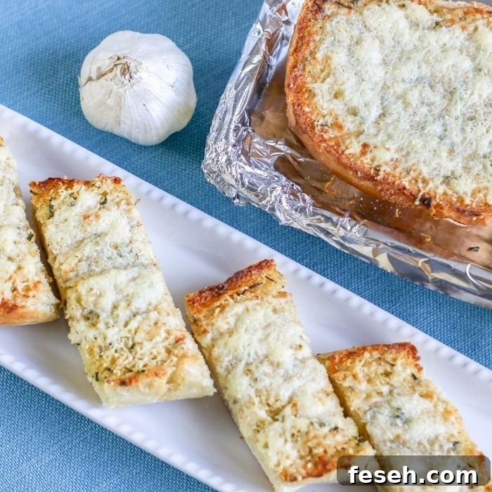 garlic bread on tray with pan of garlic bread behind it