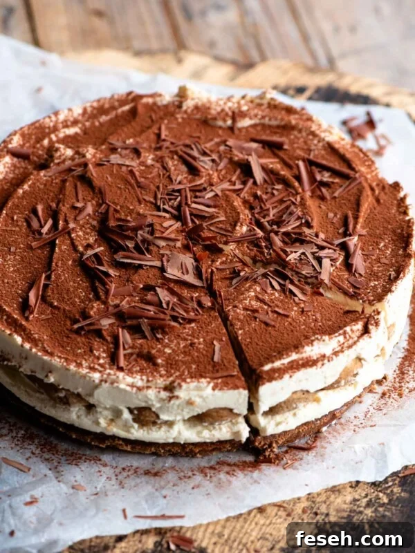 A whole tiramisu cheesecake sitting on a wooden board and parchment paper.