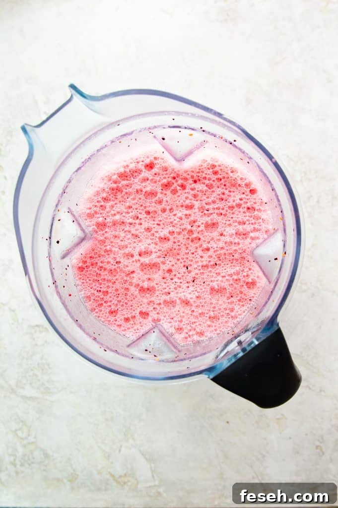 A blender full of a pink smoothie.