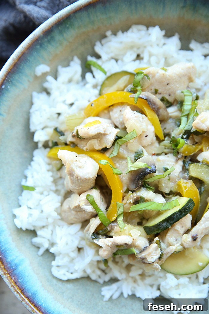 A bowl with rice and Amazing Thai Basil Chicken Curry on top.