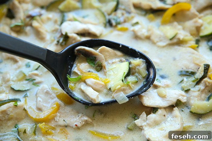 Thai basil chicken with a black serving spoon held above.