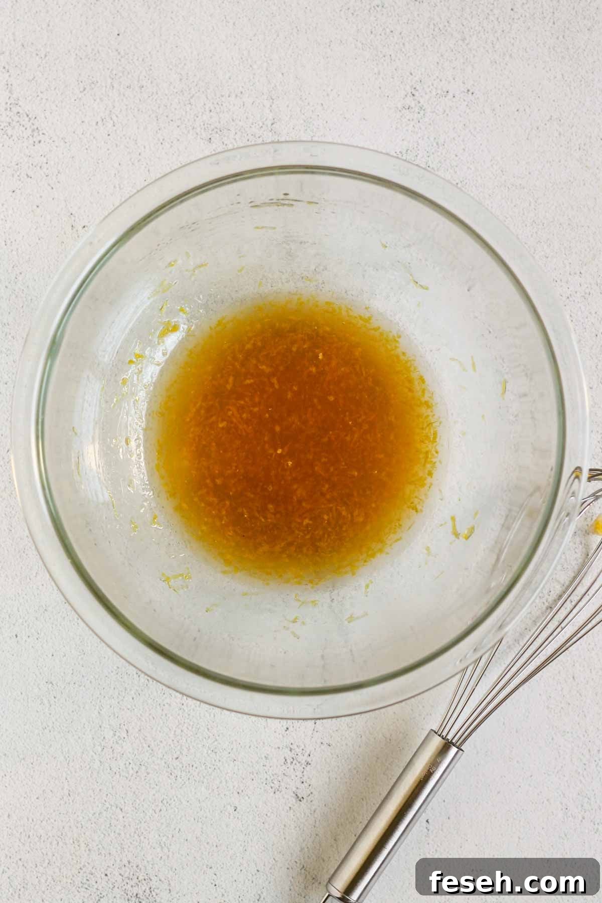 Almond flour cookie wet ingredients whisked in a glass mixing bowl.