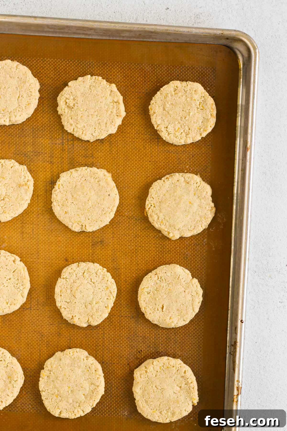 Baked almond flour cookies on a silicone mat lined baking sheet.