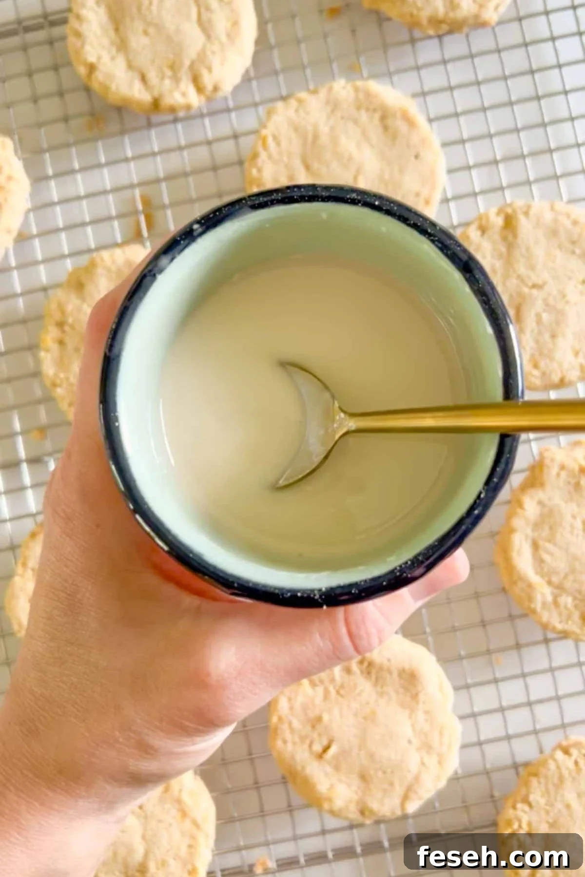 Powdered sugar glaze mixed in a small bowl with a spoon in the bowl.