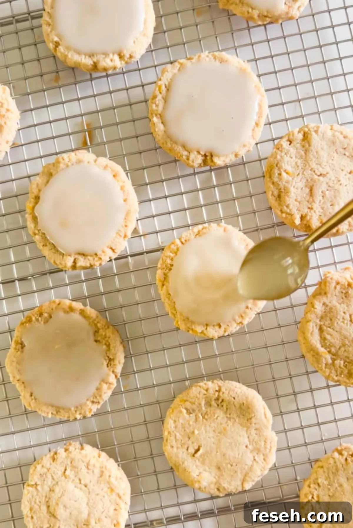 Spoon spreading glaze on top of an almond flour cookie.