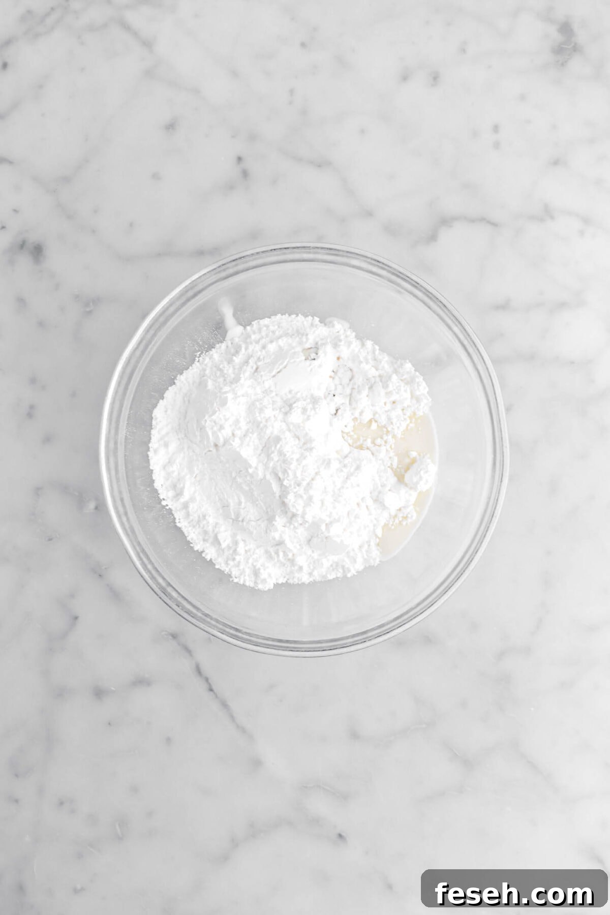 powdered sugar, milk, and vanilla in glass bowl.