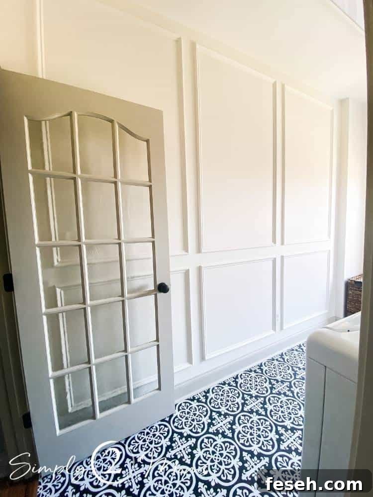 Laundry room with French doors and picture box moulding on the walls and peel and stick tiles with a hand painted ceramic tile look on the floor