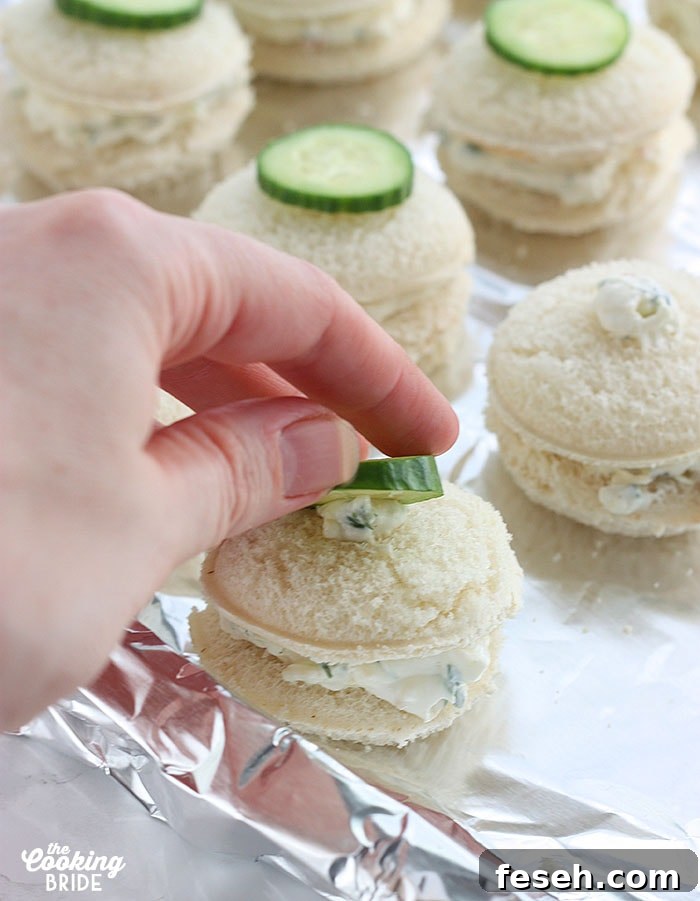 topping each sandwich with a slice of cucumber