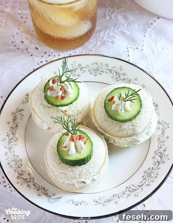 Three cucumber tea sandwiches on a white floral plate